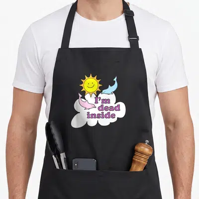Dead dorado apron - I'm dead inside purple text on white cloud with blue and pink dolphins — shown on a black cotton canvas apron against a white background