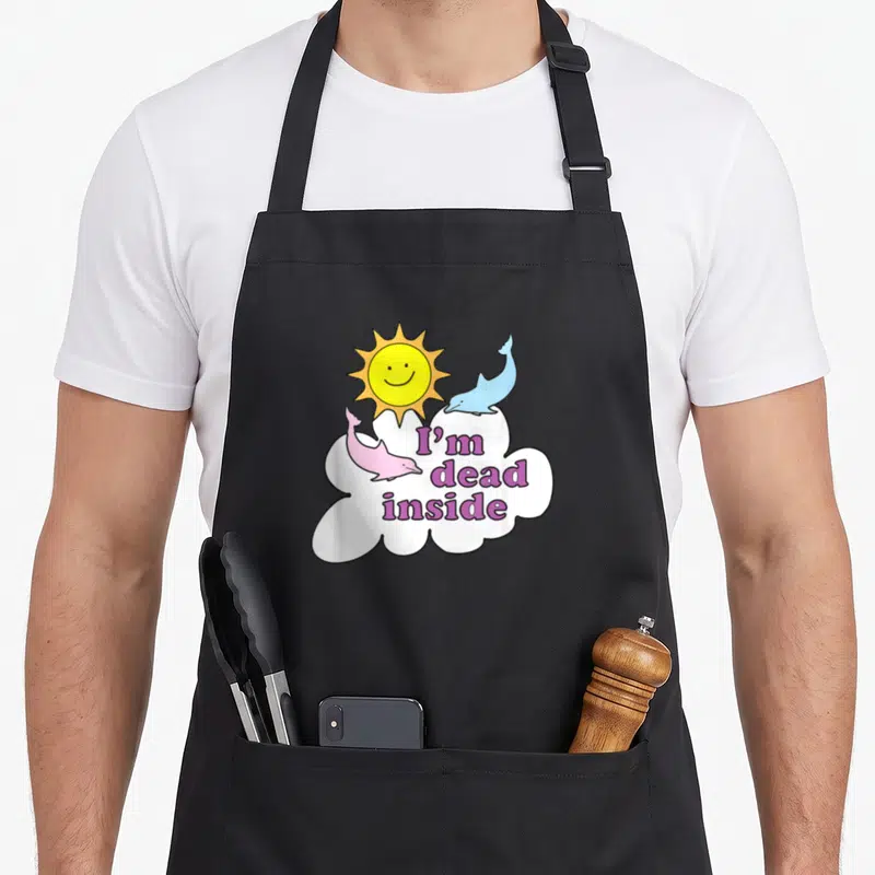 Dead dorado apron - I'm dead inside purple text on white cloud with blue and pink dolphins — shown on a black cotton canvas apron against a white background