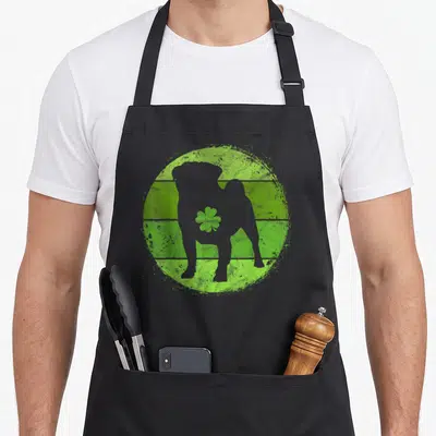 Circular st patrick day aprons - Grey dog silhouette on distressed green striped circle with shamrock — shown on a black cotton canvas apron against a white background