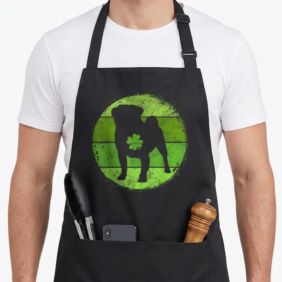 Circular st patrick day aprons - Grey dog silhouette on distressed green striped circle with shamrock — shown on a black cotton canvas apron against a white background