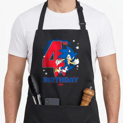 Chest birthday apron - Sonic the Hedgehog running in front of red number 4 and white stars with birthday text below — shown on a black cotton canvas apron against a white background