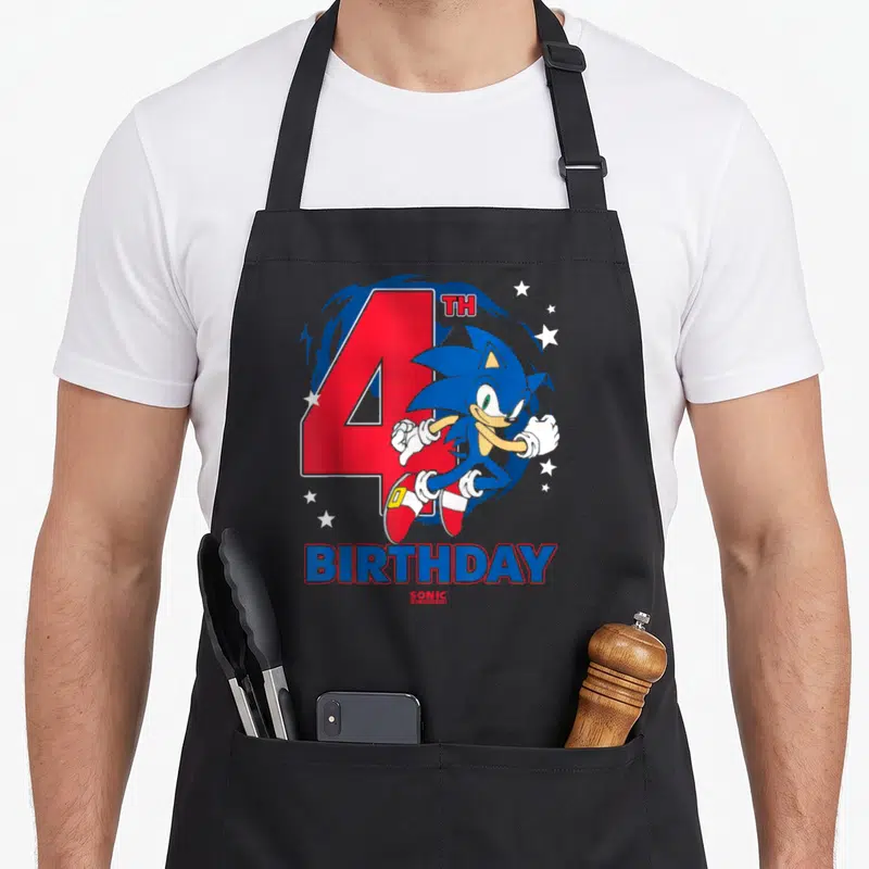 Chest birthday apron - Sonic the Hedgehog running in front of red number 4 and white stars with birthday text below — shown on a black cotton canvas apron against a white background
