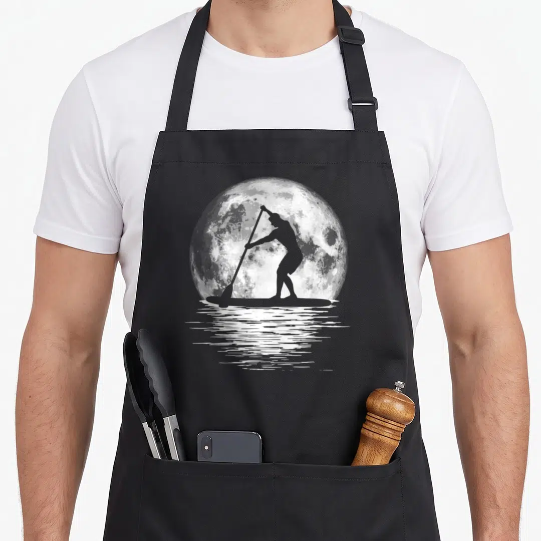 Night paddleboard apron - Grey paddleboarder silhouette on white full moon with water ripples — shown on a black cotton canvas apron against a white background