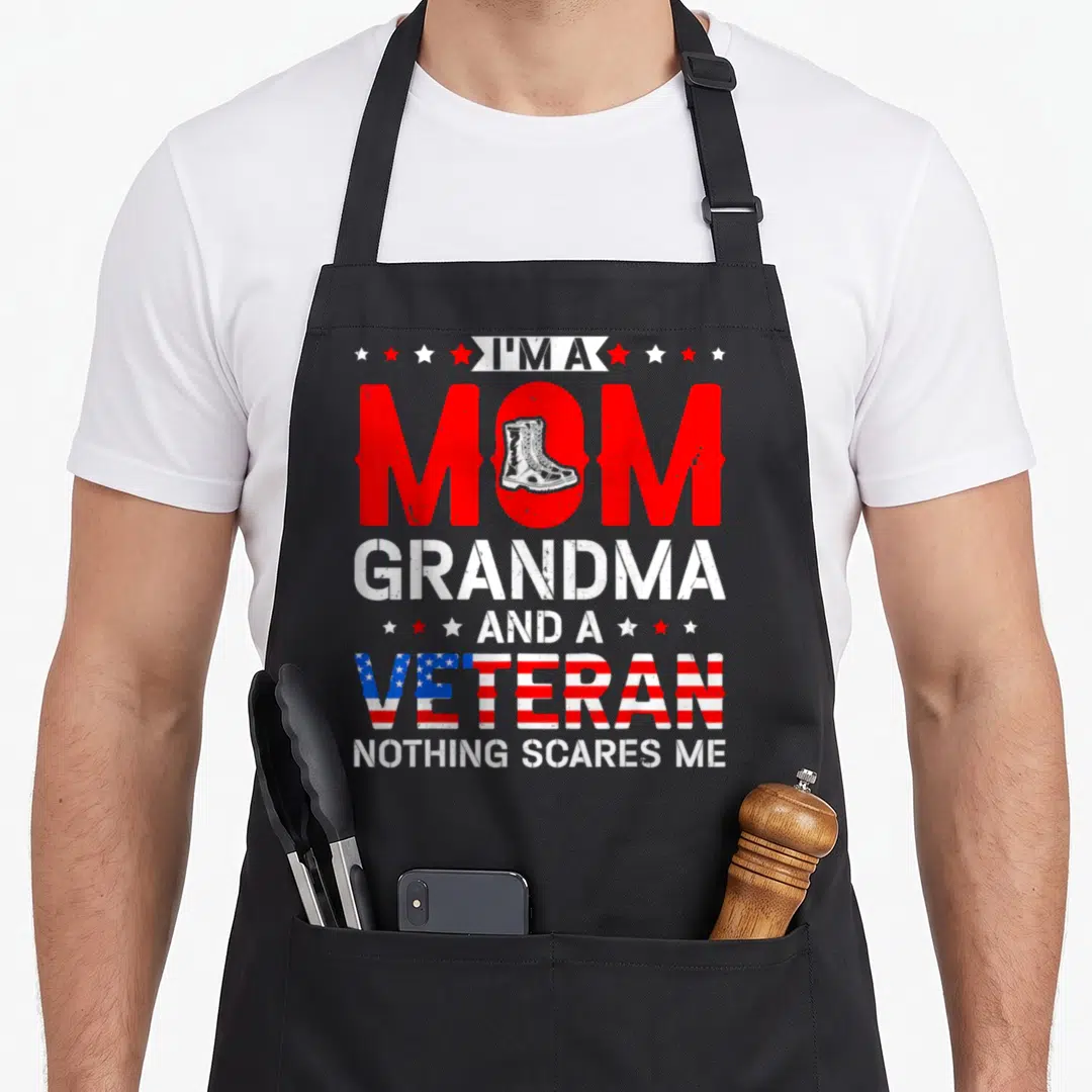 Patriotic grandma apron - Distressed red white blue text with combat boot in O and flag-filled VETERAN — shown on a black cotton canvas apron against a white background
