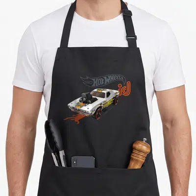 Rodger wheel apron - White toy car with orange flames and black engine details printed on canvas fabric — shown on a black cotton canvas apron against a white background