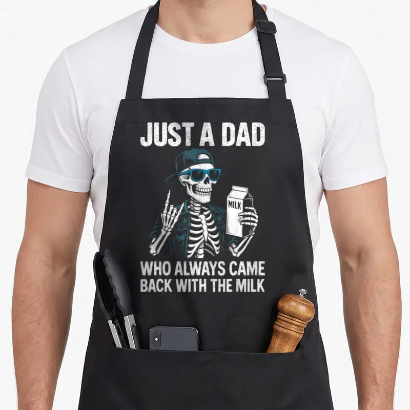Alway milk aprons - Cartoon skeleton with blue glasses holding a milk carton under white text — shown on a black cotton canvas apron against a white background