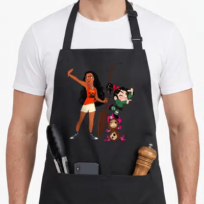 Break internet apron - #SHINY text with woman holding paddle and girl on two coconuts in cartoon style — shown on a black cotton canvas apron against a white background