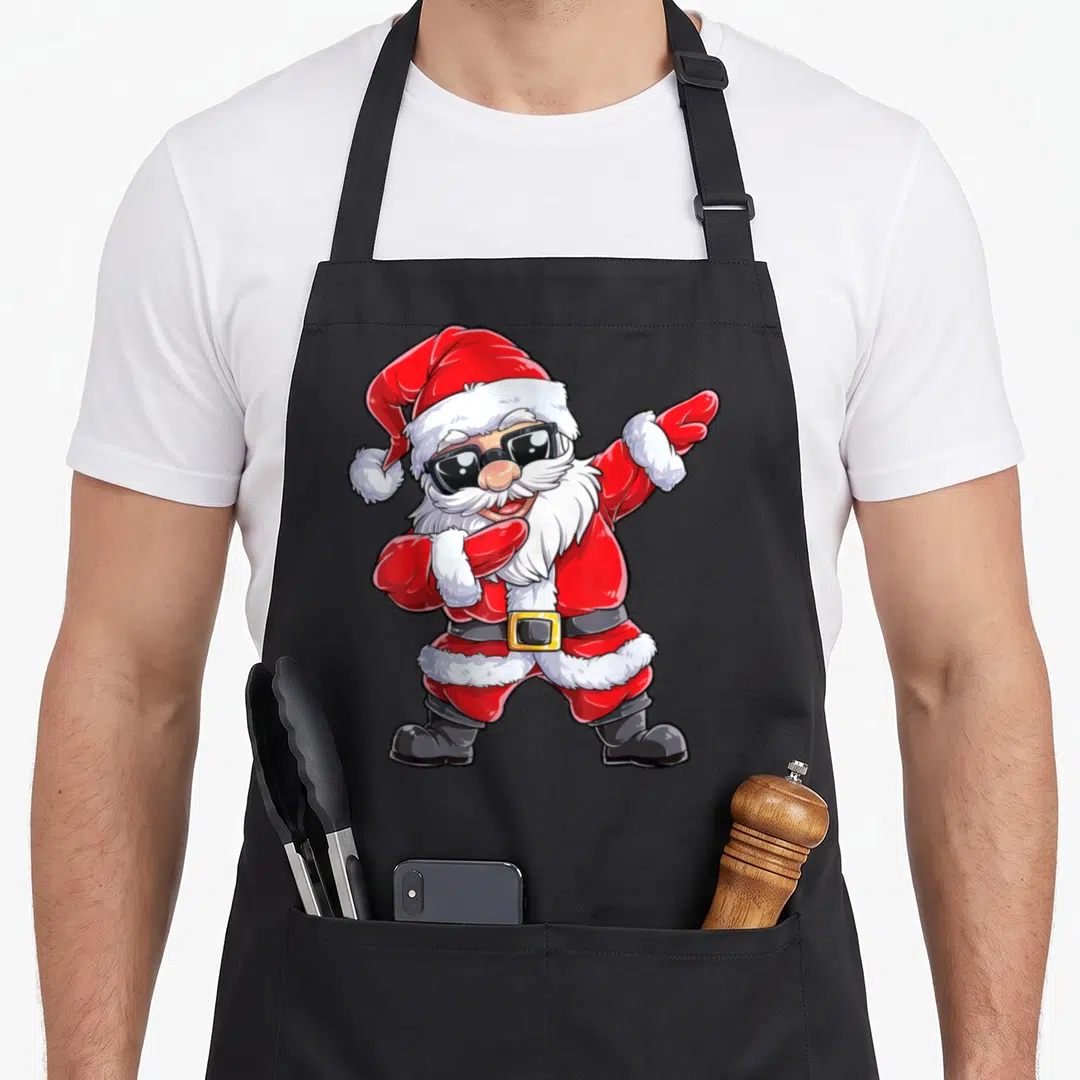 Dab santa claus apron - Cartoon Santa dabbing in red white black sunglasses — shown on a black cotton canvas apron against a white background
