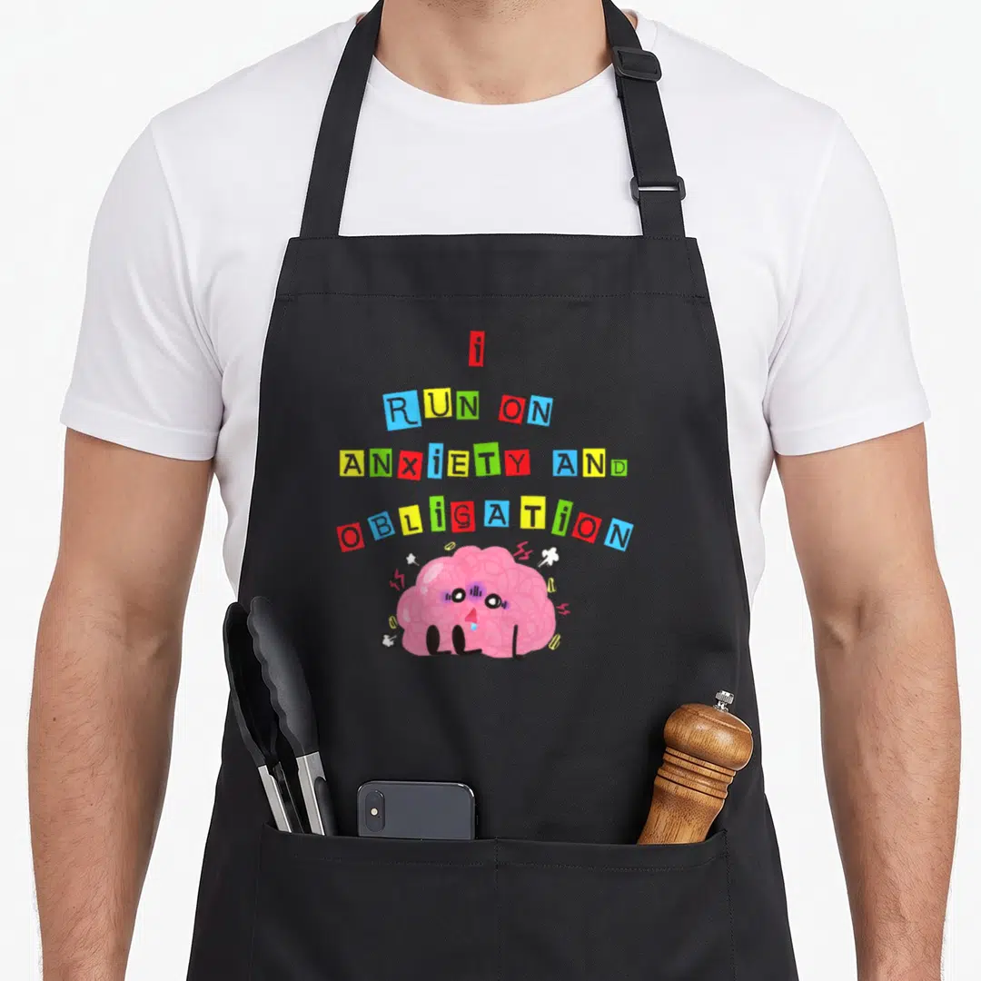 Run white pepper apron - Stacked colorful text above a crying pink cartoon brain with stress marks — shown on a black cotton canvas apron against a white background