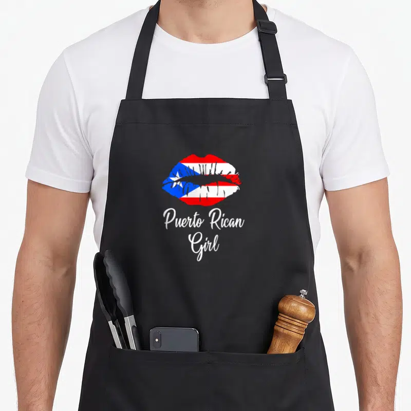 Lip pride apron - Lips filled with Puerto Rican flag pattern above white Puerto Rican Girl script text — shown on a black cotton canvas apron against a white background
