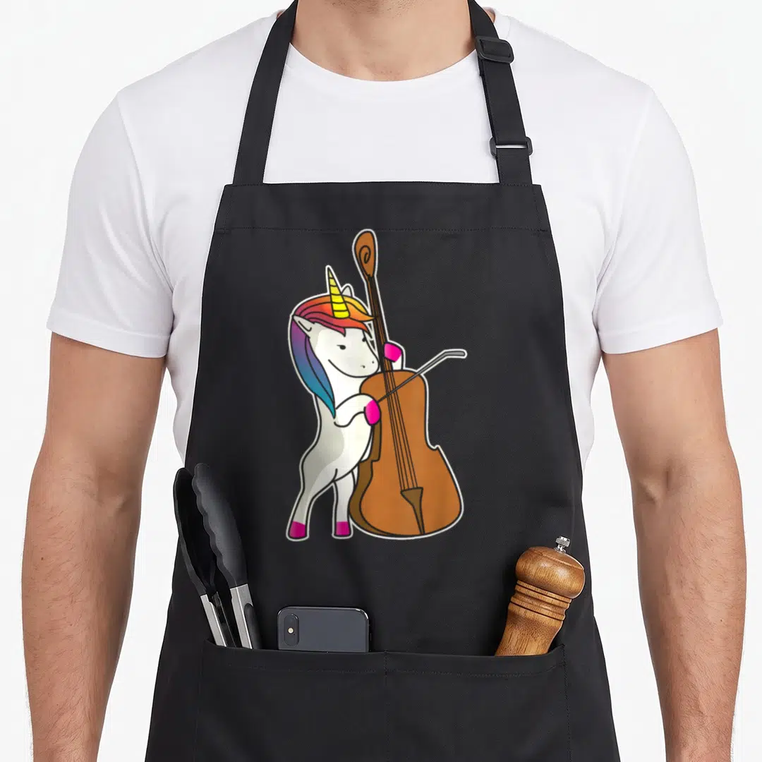 Cello unicorn apron - Cartoon white unicorn facing right playing brown double bass with pink hooves and rainbow mane — shown on a black cotton canvas apron against a white background