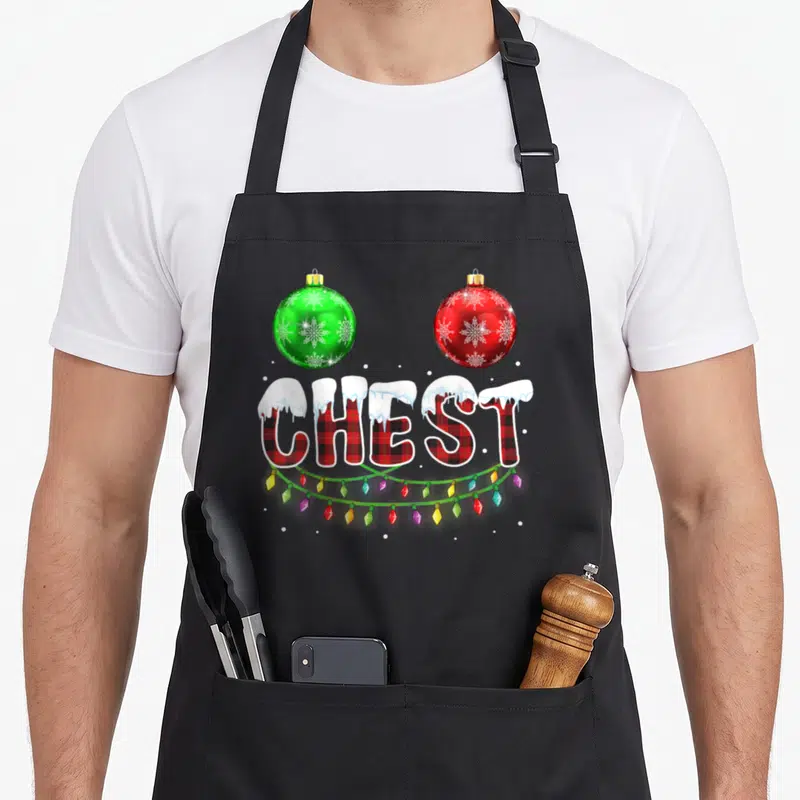 Chest nut chestnut couples christmas aprons - Snowy CHEST text with red green ornaments and multicolored lights — shown on a black cotton canvas apron against a white background