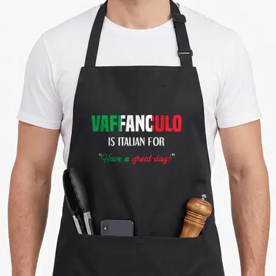 Funny vaffanculo italian apron - Stacked text VAFFANCULO filled with Italian flag colors green white red above — shown on a black cotton canvas apron against a white background