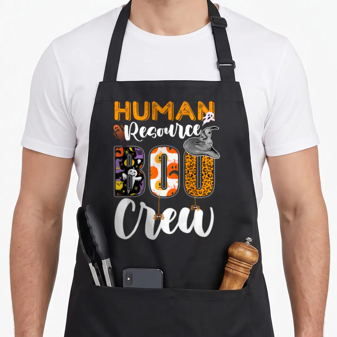 Resource halloween apron - Stacked text HUMAN Resource BOO Crew with ghosts, witch hat, spiders, pumpkin, and leopard — shown on a black cotton canvas apron against a white background