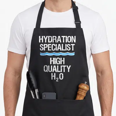 Hydration manager apron - White stacked text reading Hydration Specialist High Quality H2O with a blue wavy line divider — shown on a black cotton canvas apron against a white background