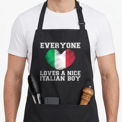 Italian flag italy apron - Heart with white green red stripes and everyone loves a nice italian boy text — shown on a black cotton canvas apron against a white background