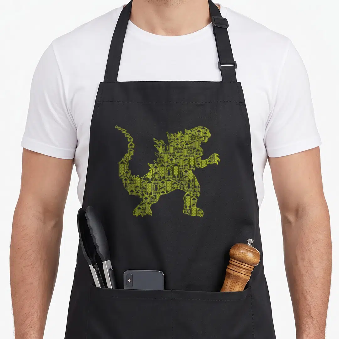 Monster dinosaur apron - Yellow monster silhouette filled with city buildings line art — shown on a black cotton canvas apron against a white background