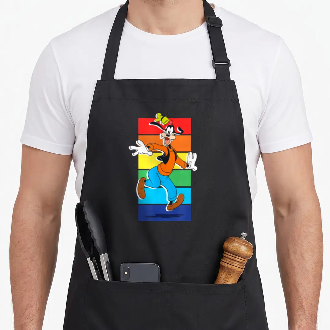 Vintage rainbow apron - Goofy running in front of vertical red orange yellow green and blue stripes with a floating — shown on a black cotton canvas apron against a white background