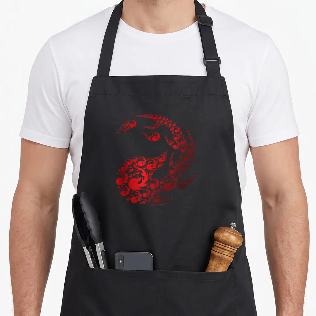 Mana icon magic apron - Red dragon shape formed by clusters of small swirls and flame-like shapes — shown on a black cotton canvas apron against a white background