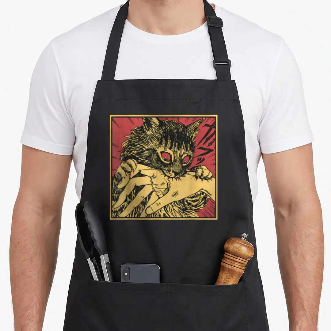 Bite black cat aprons - Cartoon black cat biting a human hand on red background with yellow border — shown on a black cotton canvas apron against a white background