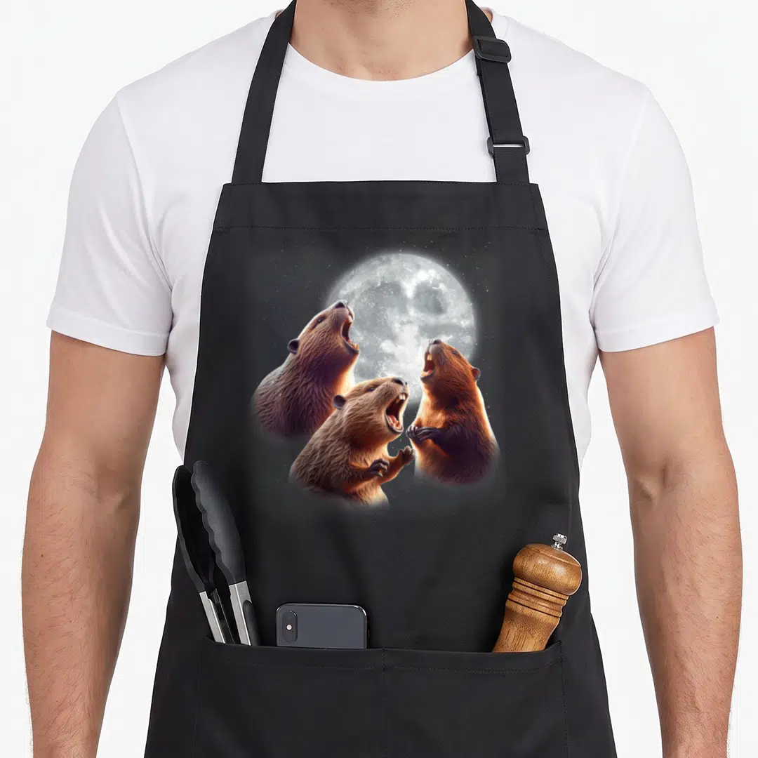 Howling beaver apron - Three realistic brown beavers howling at a large grey full moon — shown on a black cotton canvas apron against a white background