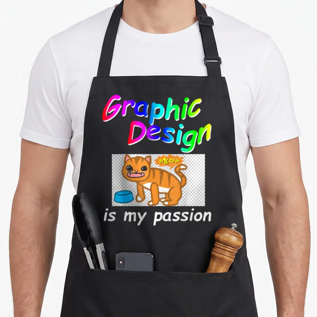 Funny passion illustrator apron - Rainbow text Graphic Design is my passion above an angry orange cat with a blue bowl — shown on a black cotton canvas apron against a white background