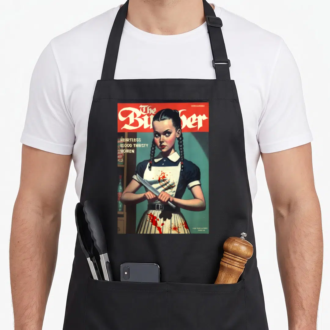 Gasp 1960s apron - Girl holding knife with text The Butcher Heartless Blood Thirsty Women in red white blue grey — shown on a black cotton canvas apron against a white background