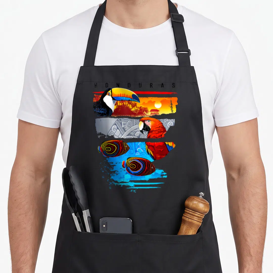 Honduras tropical print aprons - Toucan, macaw, and two fish in three colored bands under HONDURAS text — shown on a black cotton canvas apron against a white background