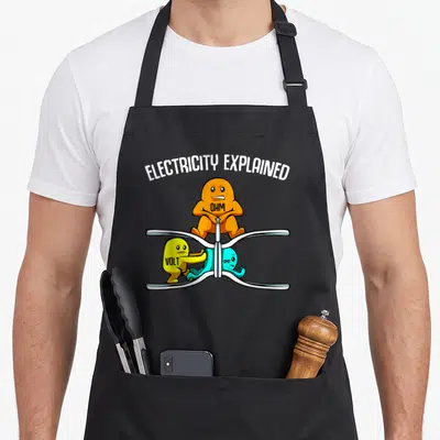 Electricity explained teacher apron - Orange Ohm character squeezes blue Amp on silver wire while yellow Volt pushes — shown on a black cotton canvas apron against a white background
