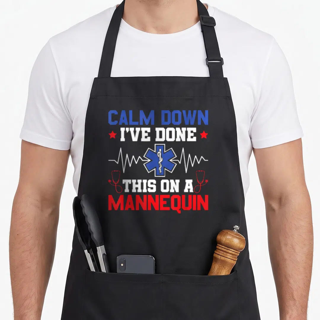 Mannequin emt apron - Star of Life with heartbeat line and text CALM DOWN I'VE DONE THIS ON A MANNEQUIN — shown on a black cotton canvas apron against a white background