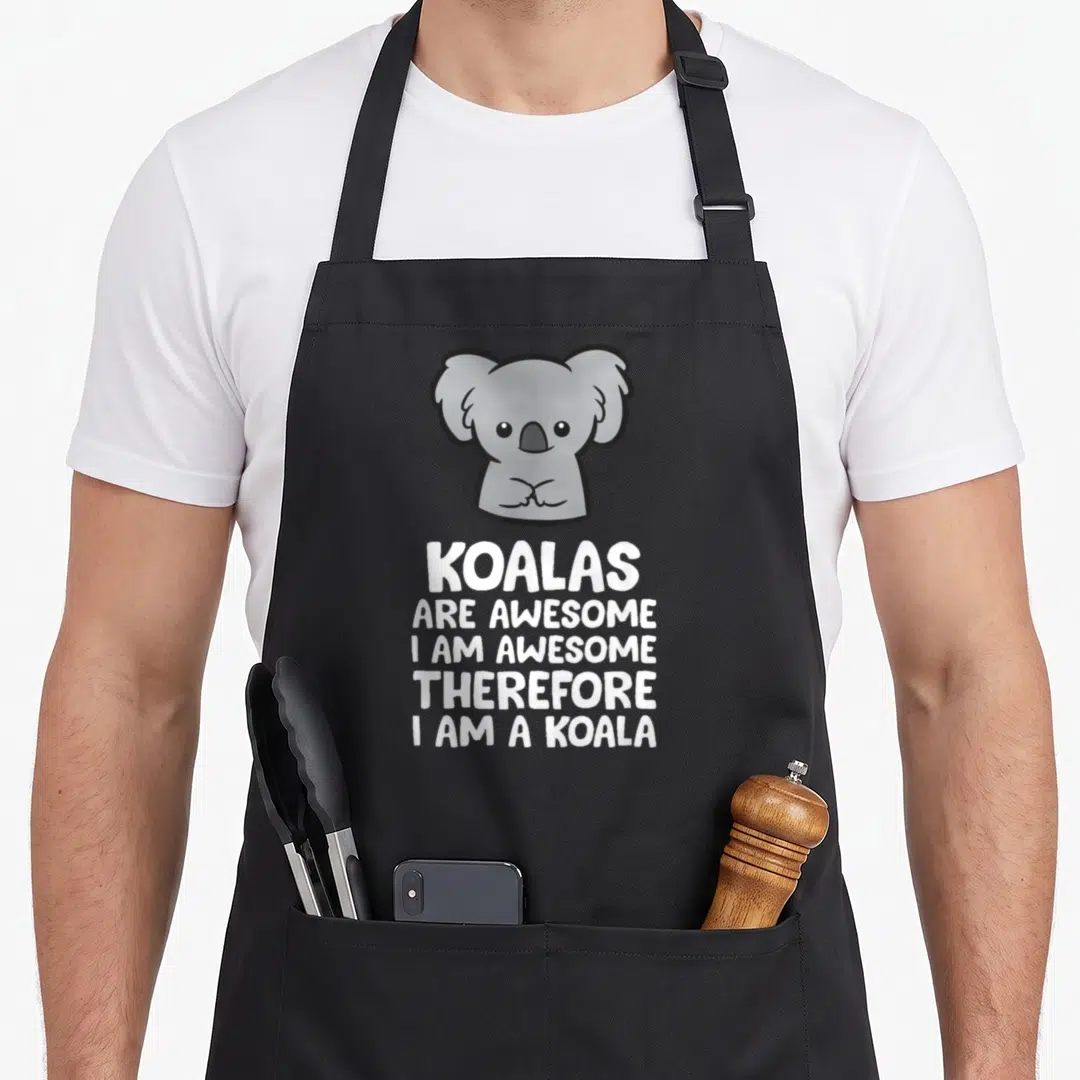 Koalas therefore apron - Cartoon grey koala above five lines of white text reading KOALAS ARE AWESOME I AM AWESOME — shown on a black cotton canvas apron against a white background