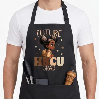 Hbcu college grad apron - Cartoon girl with backpack and stars under FUTURE HBCU GRAD text in earth tones — shown on a black cotton canvas apron against a white background