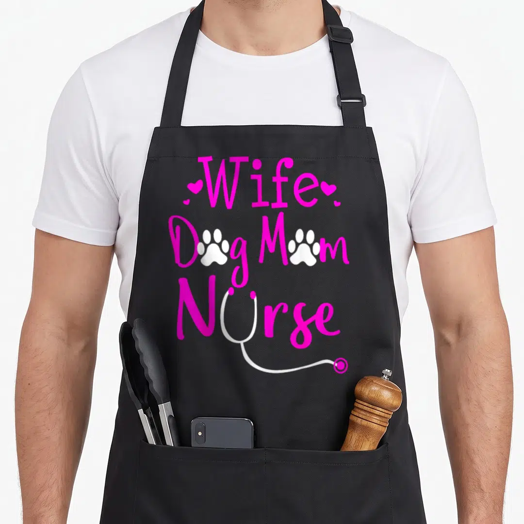 Nurse personalized dog apron - Pink text reading Wife Dog Mom Nurse with white paw prints and stethoscope graphic — shown on a black cotton canvas apron against a white background