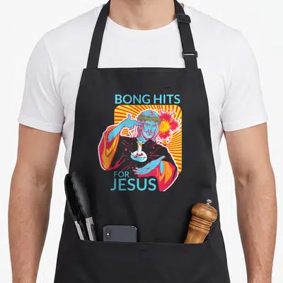 Bong april apron - Cartoon Jesus holding a bong with BONG HITS FOR JESUS text and sunburst background — shown on a black cotton canvas apron against a white background