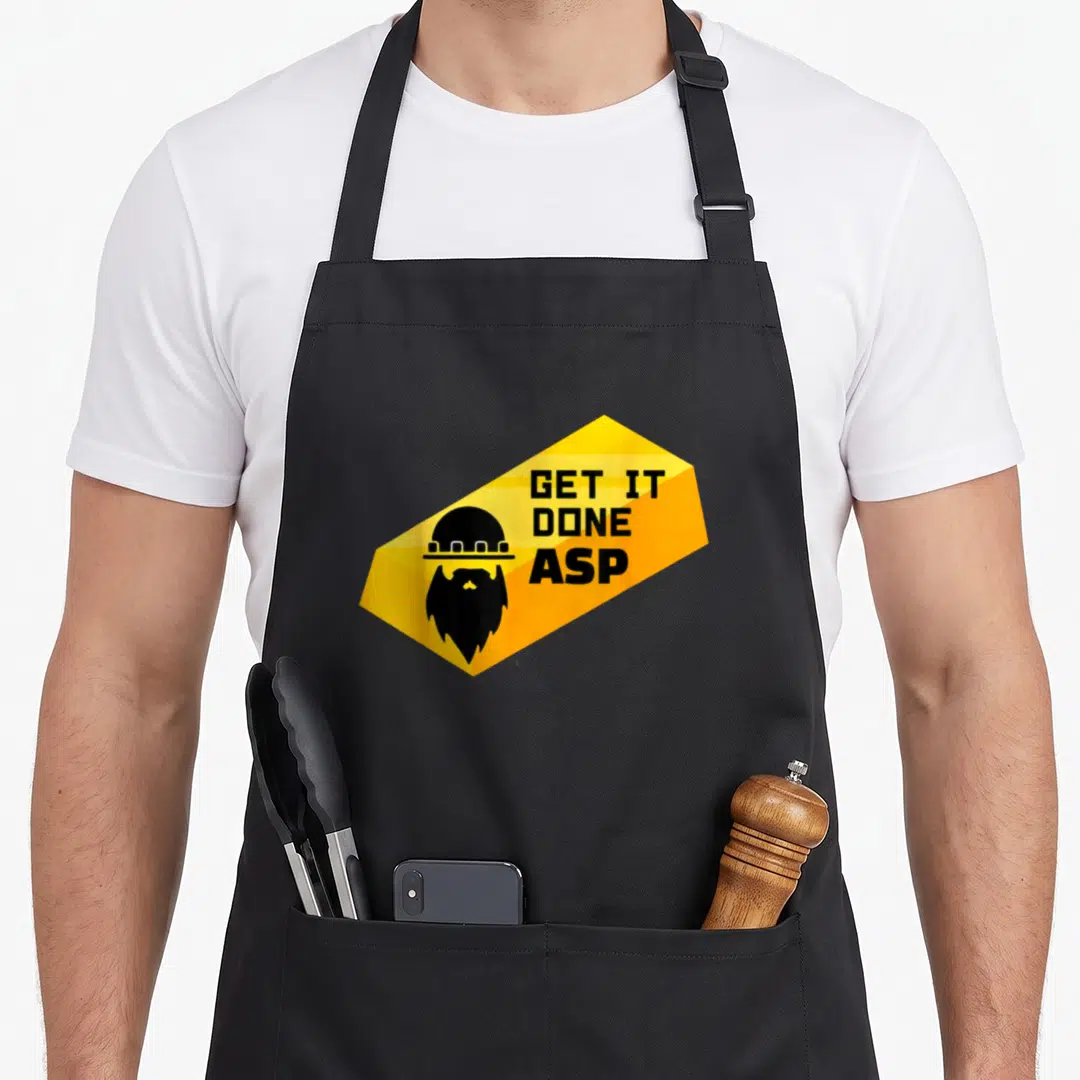Rush the miner's apron - Bearded miner silhouette and GET IT DONE ASP text inside yellow hexagon — shown on a black cotton canvas apron against a white background