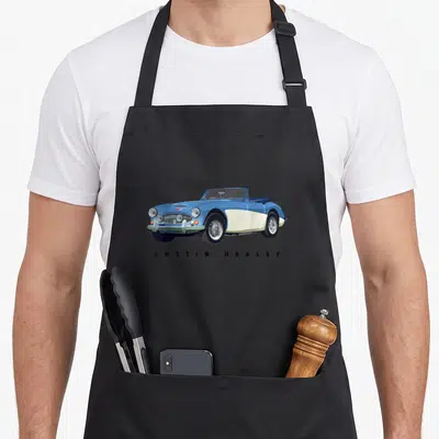 Sport car iconic apron - Blue and white Austin Healey convertible with spaced black text below — shown on a black cotton canvas apron against a white background