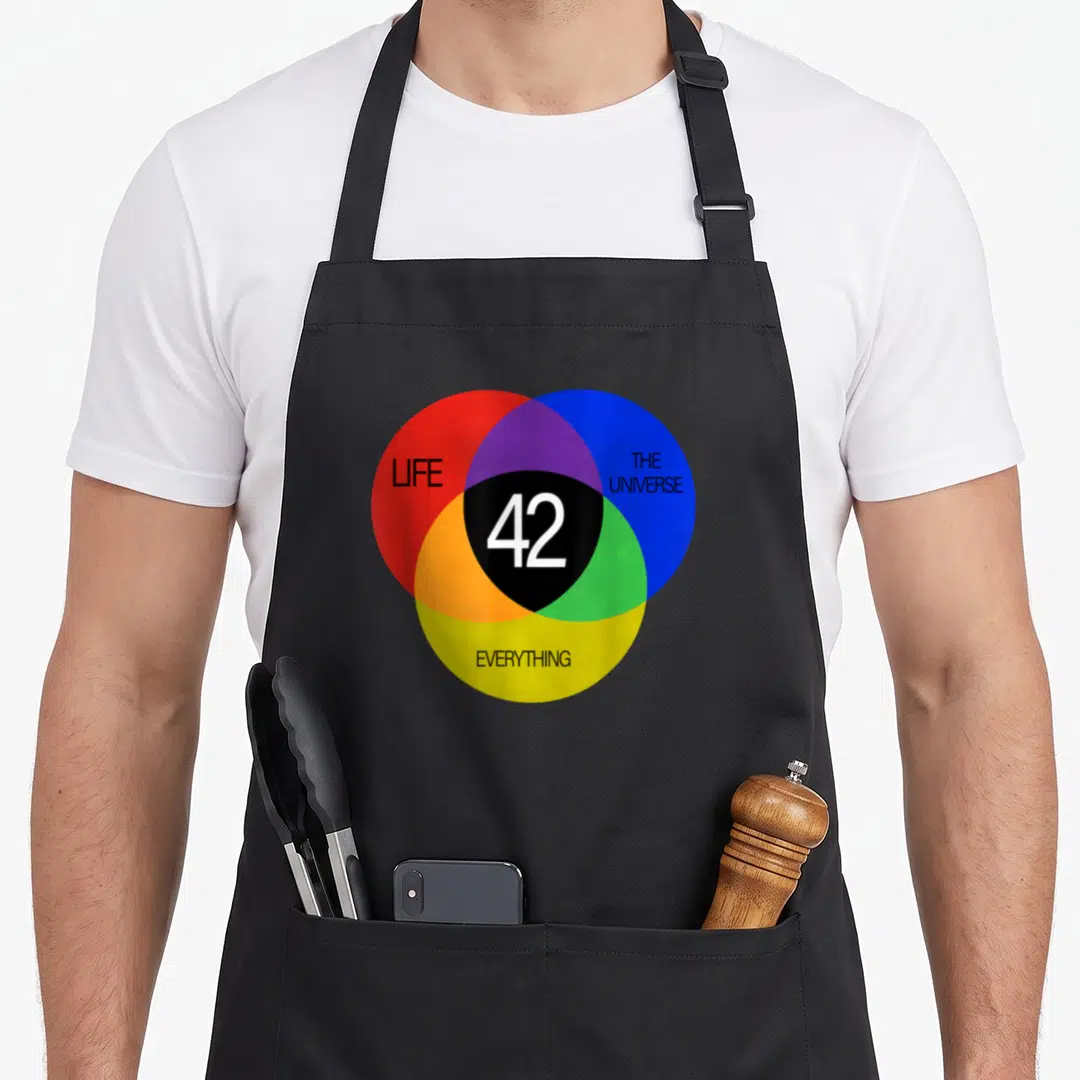 Funny answer universe apron - Venn diagram with LIFE THE UNIVERSE EVERYTHING and 42 in red blue yellow black — shown on a black cotton canvas apron against a white background