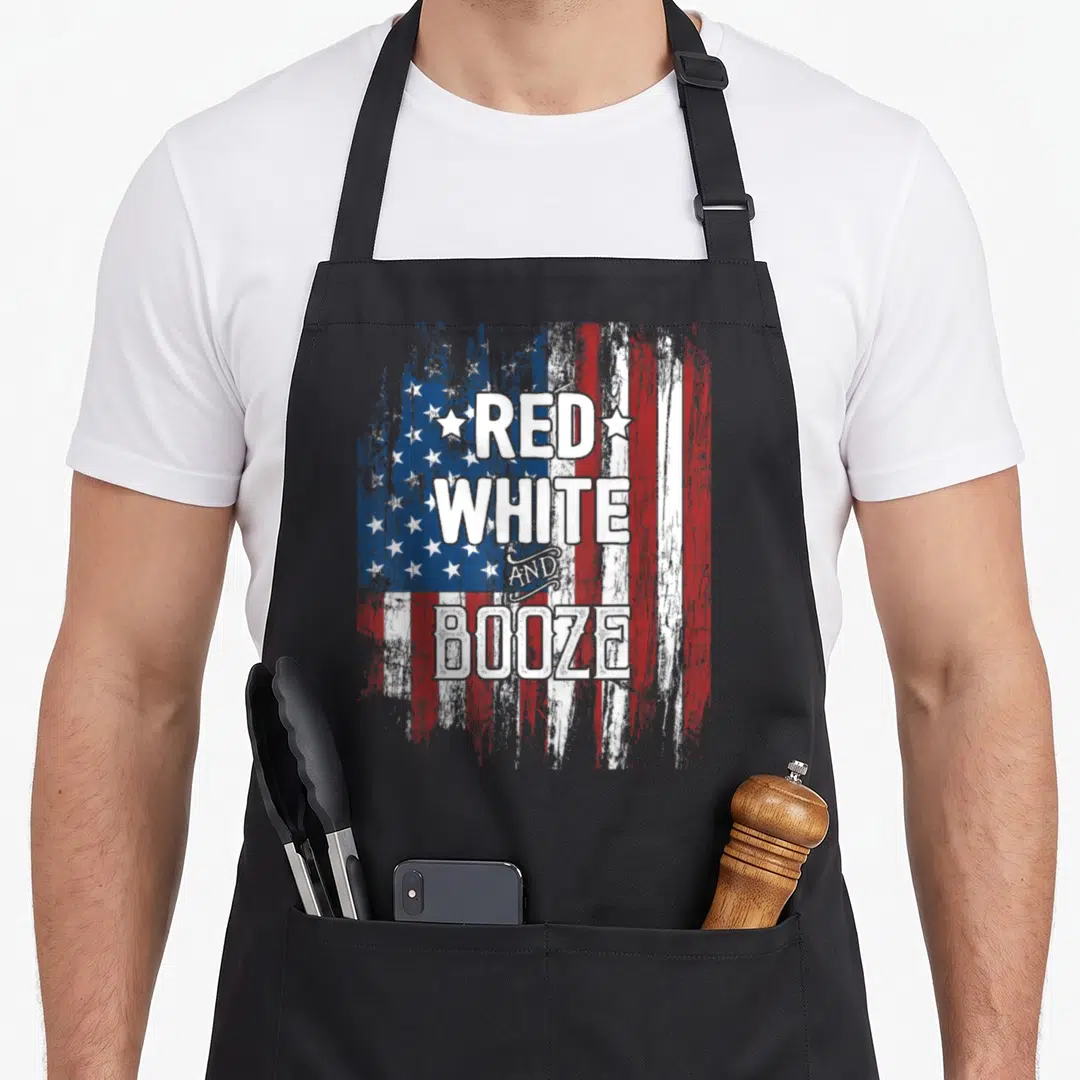 Booze 4th of july apron - Stacked red white and booze text over distressed US flag with two stars — shown on a black cotton canvas apron against a white background