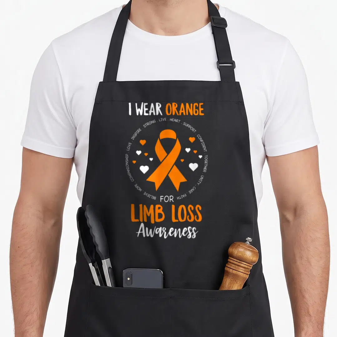 Limb ribbon apron - Orange awareness ribbon with circular text and hearts on white and orange background — shown on a black cotton canvas apron against a white background