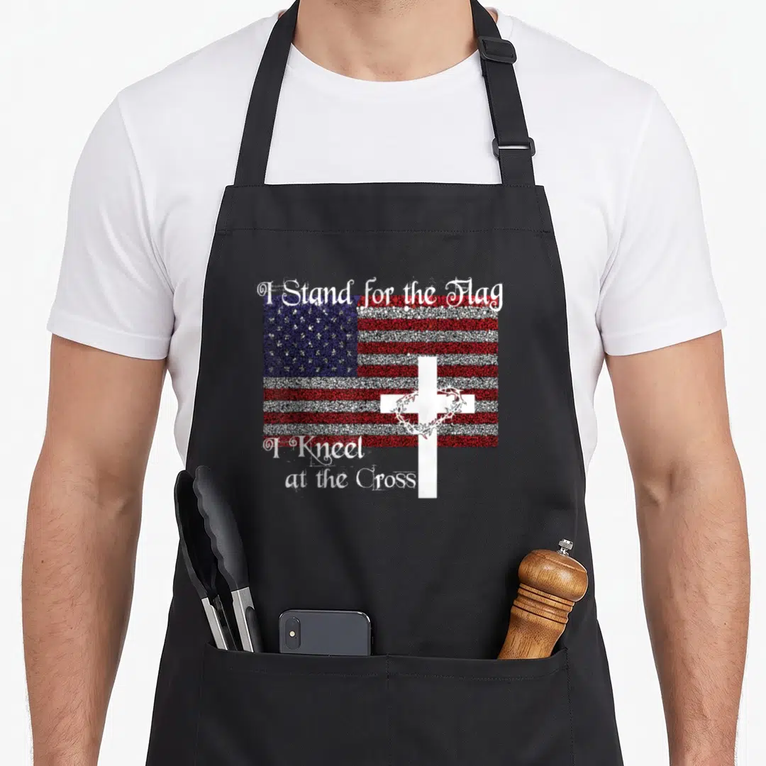 Patriotic cross apron - Distressed USA flag with white cross crown of thorns and patriotic Christian text in red white — shown on a black cotton canvas apron against a white background