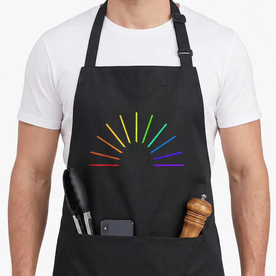 Retro rainbow apron - Nine lightsabers in red, orange, yellow, green, blue, purple fanning out from bottom center — shown on a black cotton canvas apron against a white background
