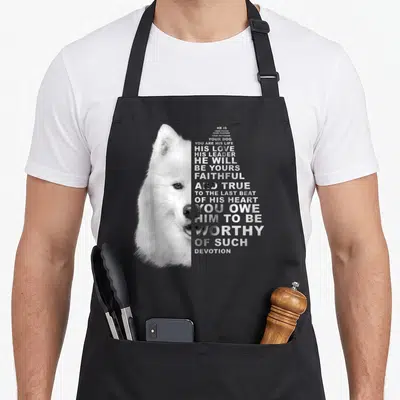 Partner samoyed dog apron - White Samoyed head photo beside stacked grey text about faithful devotion and leadership — shown on a black cotton canvas apron against a white background