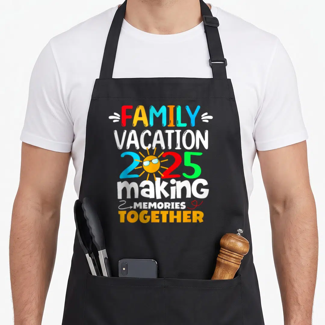 Family vacation memory apron - Stacked colorful text reading Family Vacation 2025 Making Memories Together with a sun — shown on a black cotton canvas apron against a white background