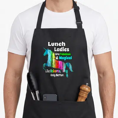 Unicorn lunch lady apron - Rainbow distressed unicorn silhouette with text lunch ladies are fabulous and magical like — shown on a black cotton canvas apron against a white background