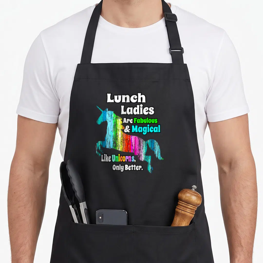 Unicorn lunch lady apron - Rainbow distressed unicorn silhouette with text lunch ladies are fabulous and magical like — shown on a black cotton canvas apron against a white background