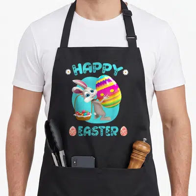 Easter bunny basket apron - Cartoon bunny holding basket and large egg with HAPPY EASTER text in light blue — shown on a black cotton canvas apron against a white background