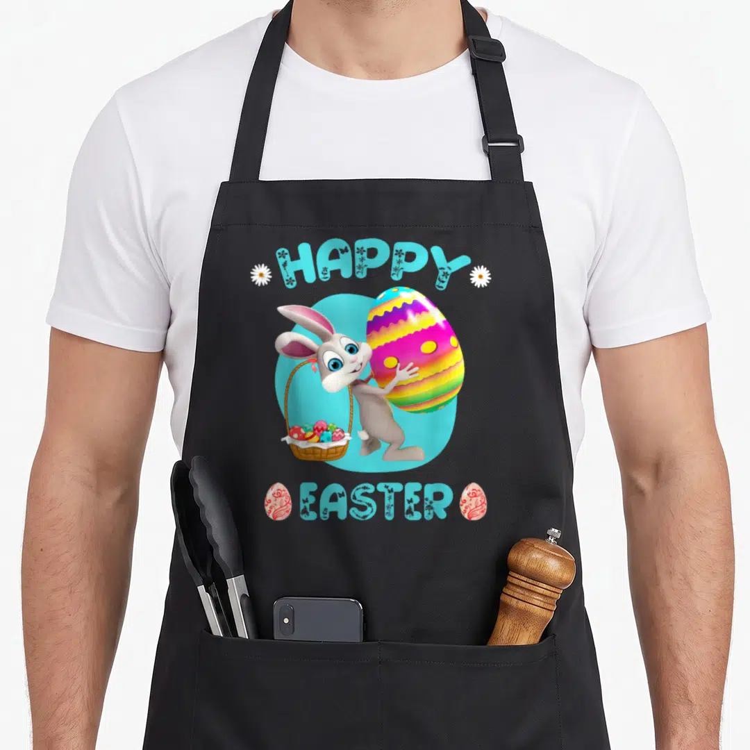 Easter bunny basket apron - Cartoon bunny holding basket and large egg with HAPPY EASTER text in light blue — shown on a black cotton canvas apron against a white background