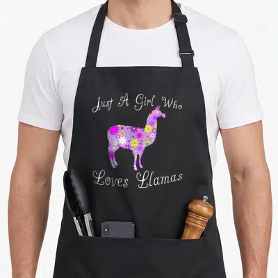 Funny llama lover apron - Floral purple llama silhouette with white script text Just A Girl Who Loves Llamas — shown on a black cotton canvas apron against a white background