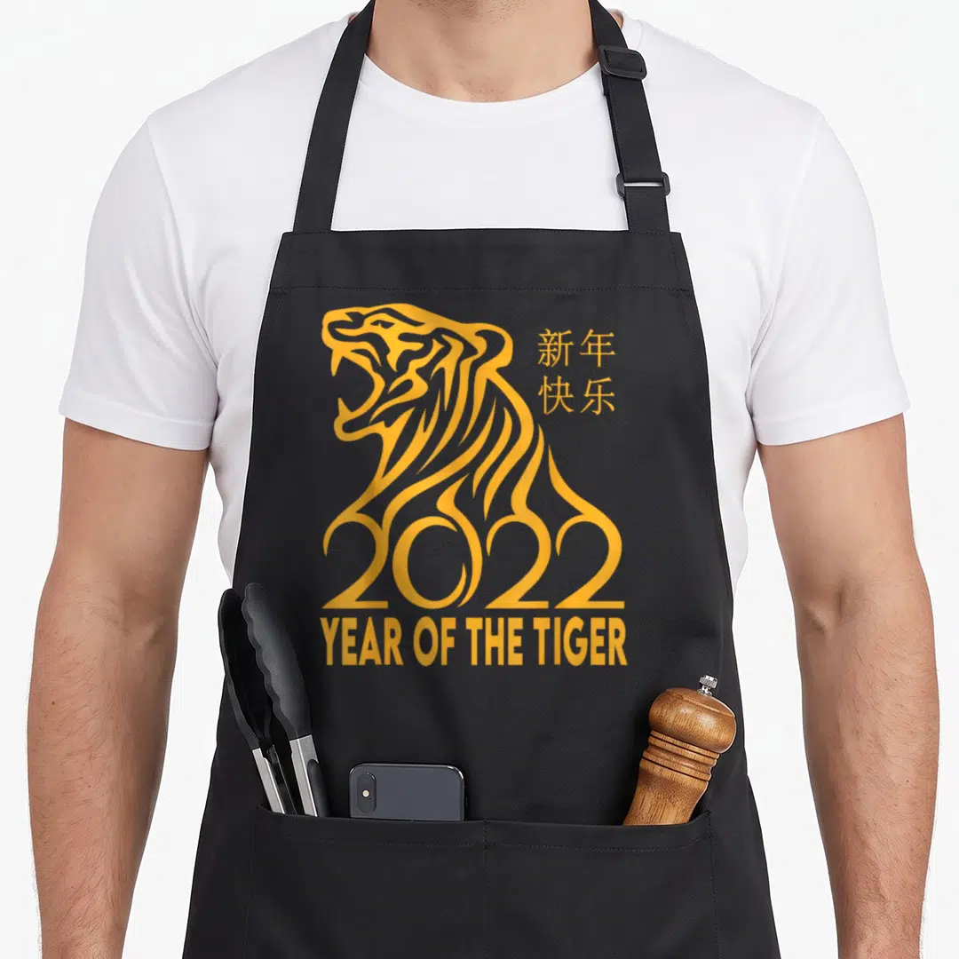 Tiger chinese zodiac apron - Yellow line art tiger forming 2022 with Chinese text and Year of the Tiger label — shown on a black cotton canvas apron against a white background