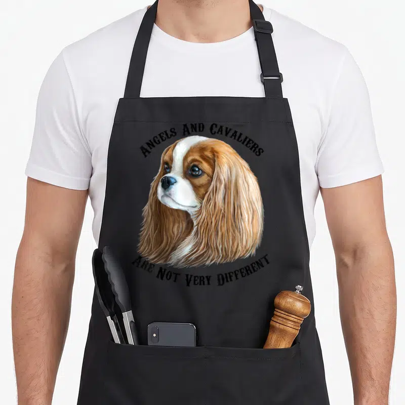 Blenheim king apron - Realistic brown and white spaniel head with arched text reading Angels and Cavaliers Are Not Very — shown on a black cotton canvas apron against a white background